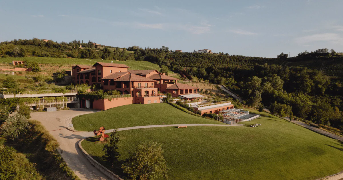 Aerial view of Casa di Langa, a terracotta-coloured resort set among lawns, vineyards and hazelnut groves in the Langhe.