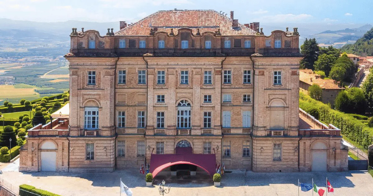 The eighteenth-century facade of Castello di Guarene above its formal gardens, with the Piedmont plain stretching out behind.